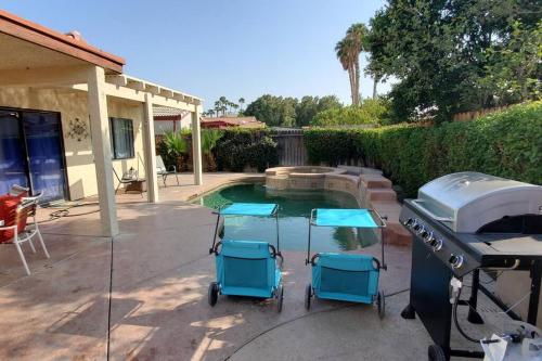 a grill and stools next to a swimming pool at Bikini & Martini on Palm Meadows Drive in Indio