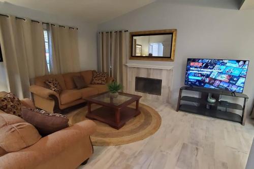 a living room with a couch and a tv at Bikini & Martini on Palm Meadows Drive in Indio