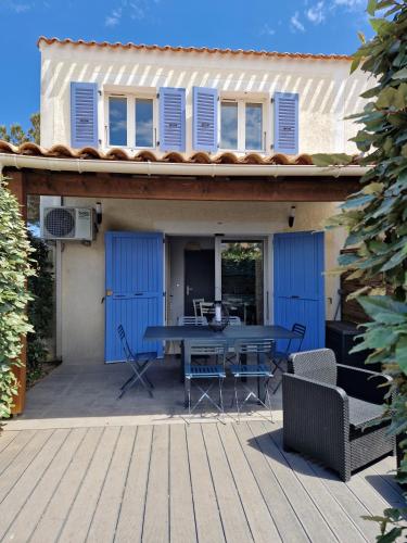 une terrasse avec une table et des chaises dans une maison dans l'établissement MARINA ILE DES PECHEURS, au Barcarès