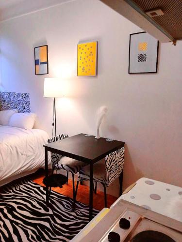 a room with a bed and a table with a lamp at Appartement entier à Neuilly-sur-Seine in Neuilly-sur-Seine