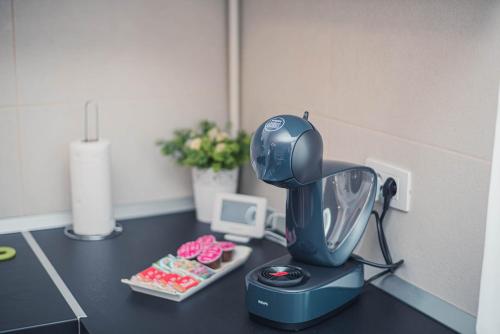 a kitchen counter with a blue mixer on a table at White Mood Apartment Brasov in Braşov