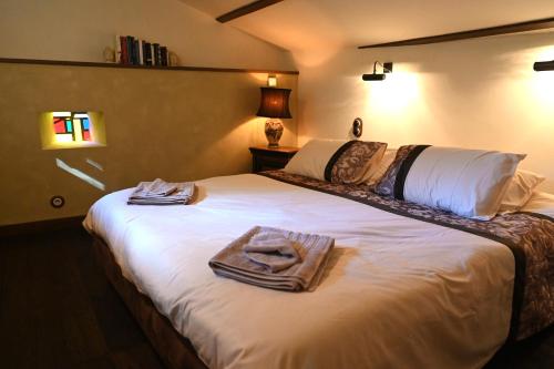 une chambre avec un lit blanc avec des serviettes dessus dans l'établissement La Maison De L'Ecrivain, à La Bastide-lʼÉvêque