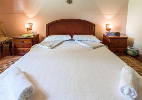 a bedroom with a large white bed with two night stands at El Laurel Finca Agroturistica in Quimbaya