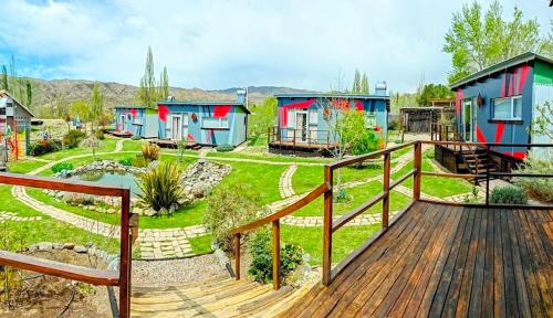 a home with a deck and a yard with houses at CASA FARO ARTE in Potrerillos