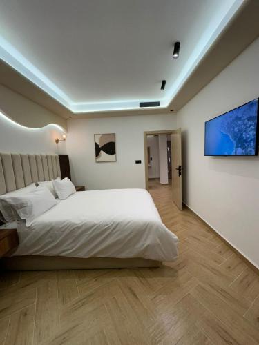 a bedroom with a white bed and a flat screen tv at Centrico 6 Confort & Luxe au Centre in Tangier