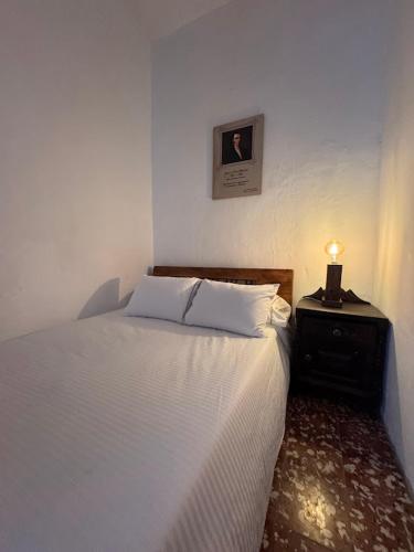 a bedroom with a bed and a night stand with a lamp at Casa Rionegro Colonial in Rionegro