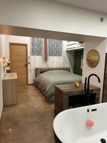 - une chambre avec un lit, un lavabo et une baignoire dans l'établissement Appartement 2 personnes, à Châteauneuf-de-Gadagne