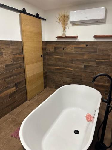 La salle de bains est pourvue d'une baignoire blanche et d'une fenêtre. dans l'établissement Appartement 2 personnes, à Châteauneuf-de-Gadagne