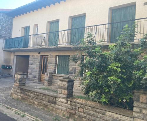 a brick house with a balcony and a fence at Chez Douddine in Pont-du-Château