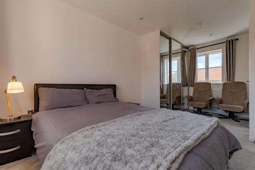 a bedroom with a bed and a table and chairs at Luxurious 2 Bed House near Birmingham in Bilston