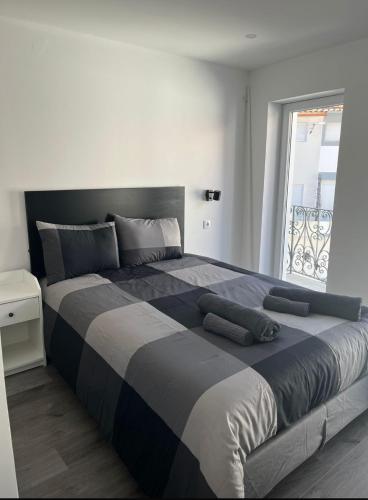 a large bed in a bedroom with a window at H I Alojamento in Manteigas