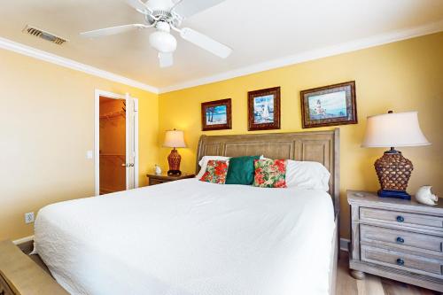a bedroom with a white bed and a ceiling fan at Dawn Condominiums - Break of Dawn in Galveston