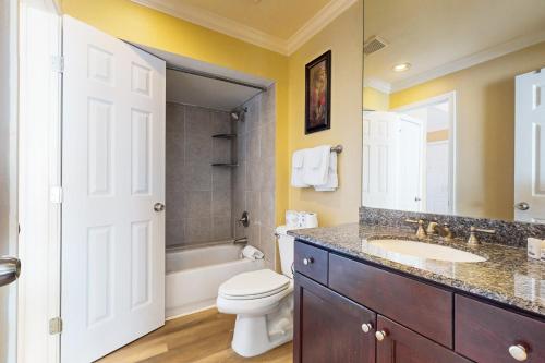a bathroom with a toilet and a sink and a tub at Dawn Condominiums - Break of Dawn in Galveston