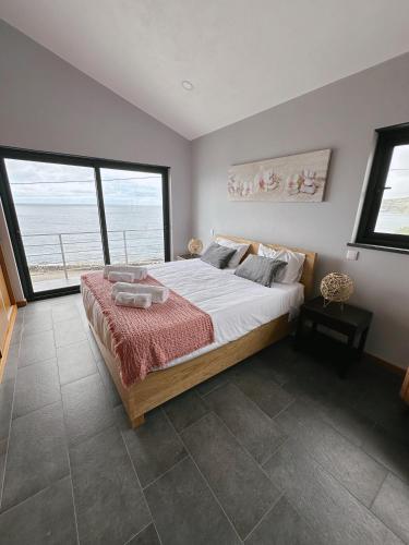 a bedroom with a large bed and a large window at Miramar in Angra do Heroísmo