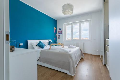 a blue bedroom with a bed and a blue wall at House Of The Dragon in Acilia
