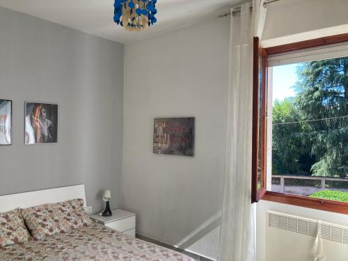 a bedroom with a bed and a window at Casa Chiara tra Saronno e Milano in Saronno