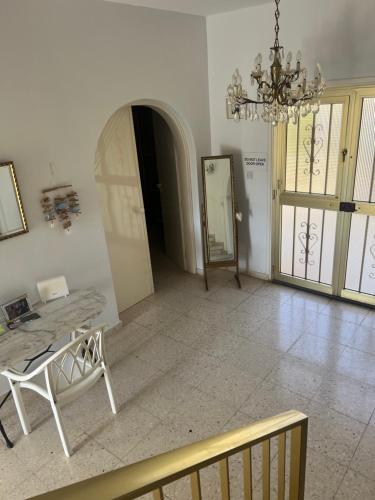a living room with a table and a chandelier at Erini Villa in Protaras