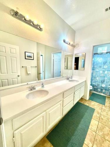 a bathroom with two sinks and a large mirror at Happy Hour & Sunshine in Indio