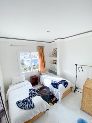a bedroom with two beds and a window at Locals Taghazout surfcamp in Taghazout