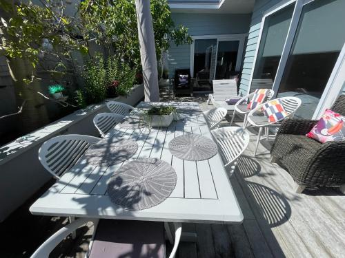 a table with umbrellas sitting on a deck at Downtown Mount Cottage in Mount Maunganui