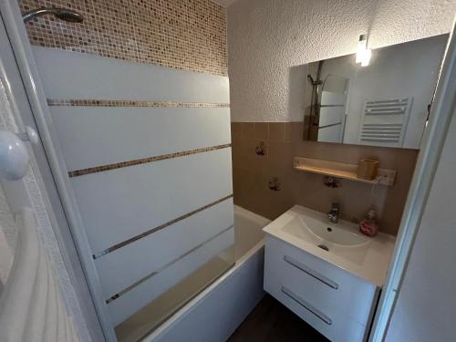 a bathroom with a white sink and a mirror at Studio Risoul 1850 in Risoul