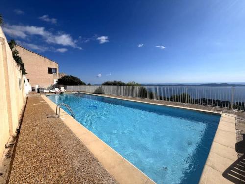 une piscine avec l'océan en arrière-plan dans l'établissement Charmant studio avec terrasse privée et vue exceptionnelle, à Hyères