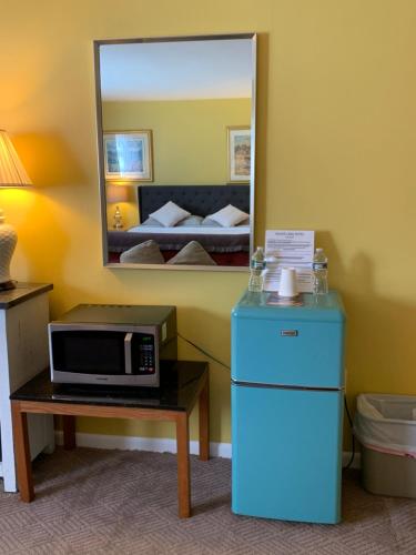 a room with a microwave on a table and a mirror at Grand Lake Hotel in Lebanon