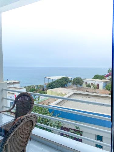 a balcony with two chairs and a view of the ocean at Locals Taghazout surfcamp in Taghazout