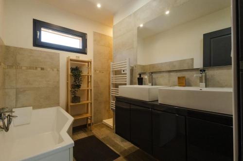 une salle de bain avec deux lavabos et un grand miroir dans l'établissement Villa Maudroume, à Bormes-les-Mimosas
