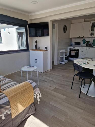 a kitchen and living room with a couch and a table at Vivenda BRANCA in Carcavelos