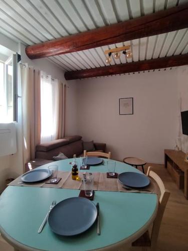 un salon avec une table avec des assiettes bleues dessus dans l'établissement Appartement centre-ville Orange, à Orange