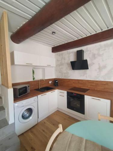 une cuisine avec un évier et une machine à laver dans l'établissement Appartement centre-ville Orange, à Orange