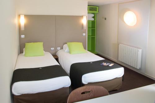 two beds in a room with green and white at Campanile Nantes Saint-Sébastien-Sur-Loire in Saint-Sébastien-sur-Loire