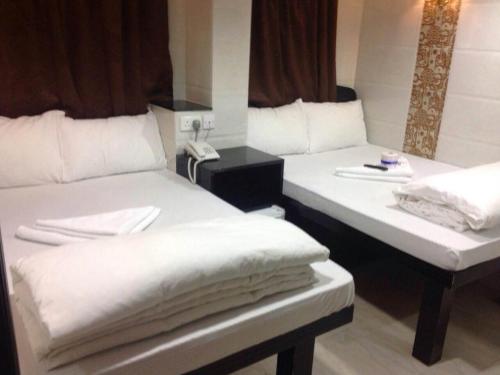 a room with two beds and a phone in it at New Euro Asia Guest House in Hong Kong