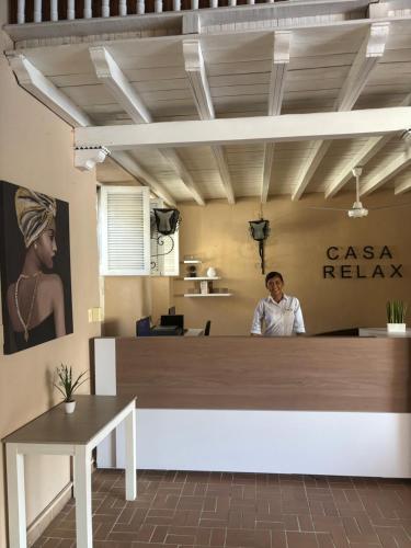 un hombre sentado en una recepción en una oficina en Casa Relax Hotel, en Cartagena de Indias