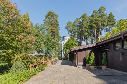 a walkway in a park with trees and a building at Kallhällsbaden Strandhotell in Stockholm