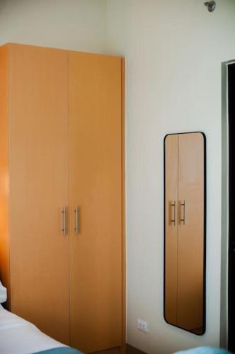 a bedroom with a mirror next to a wardrobe at Paladium Iloilo Smart Home Condo in Iloilo City