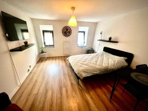 a bedroom with a bed and a wooden floor at T1 Tout confort aux porte de Strasbourg in Strasbourg