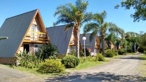 a house with palm trees in front of a road at Cabañas LAS PALMERAS in La Paz