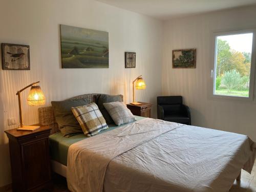 une chambre avec un lit avec deux lampes et une fenêtre dans l'établissement Agréable et confortable maison Le Vigan en Quercy, au Vigan