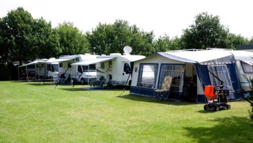 a row of tents parked in a field at 'Hunebed Chalet' - De Tien Heugten in Schoonloo