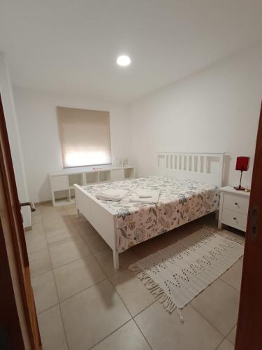 een witte slaapkamer met een bed en twee nachtkastjes bij Apartamento Rota do Sol in Armação de Pêra
