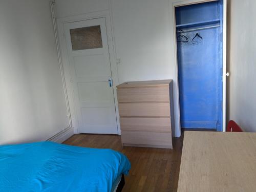 - une chambre avec un lit bleu et une commode dans l'établissement Chambre double confortable, au calme et proche du centre-ville de Lyon, à Lyon