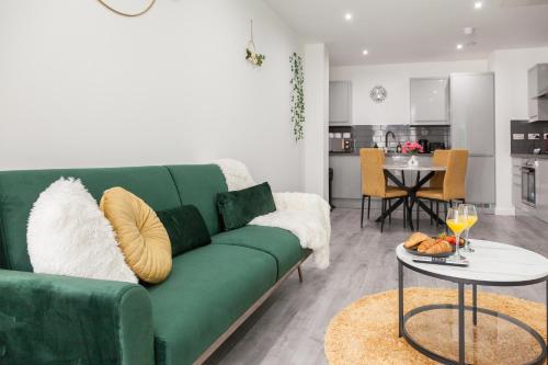 a living room with a green couch and a table at Opulent Residence - 1 BR Leicester City Centre in Leicester