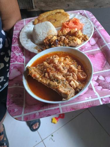a table with a bowl of food and a plate of bread at HOSPEDAJE DOÑA NEL in El Valle