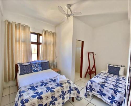 une chambre avec deux lits et une fenêtre dans l'établissement Pousada Caminho do Mar, à Santa Cruz Cabrália