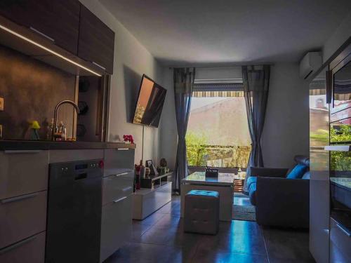 - une cuisine avec un salon doté d'un canapé dans l'établissement Appartement au cœur du lavandou - plage à 200m, au Lavandou