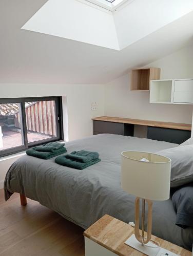 - une chambre avec un lit et des serviettes vertes dans l'établissement Loft pays basque, à Anglet