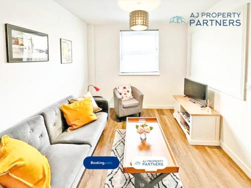 a living room with a couch and a tv at Premium Offer l Last-Minute Escape l AJ Properties l High Street Cheltenham l Parking l Ideal for Short or Long Stays - Town Centre Apartment, 4 Beds, 1 Bathroom in Cheltenham