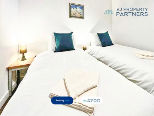 two beds sitting next to each other in a room at Premium Offer l Last-Minute Escape l AJ Properties l High Street Cheltenham l Parking l Ideal for Short or Long Stays - Town Centre Apartment, 4 Beds, 1 Bathroom in Cheltenham